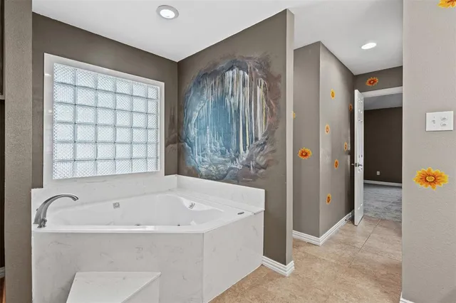 an empty room with wooden floor fireplace and windows