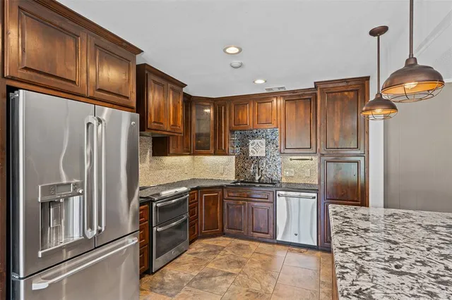 a kitchen with stainless steel appliances granite countertop a stove and a refrigerator