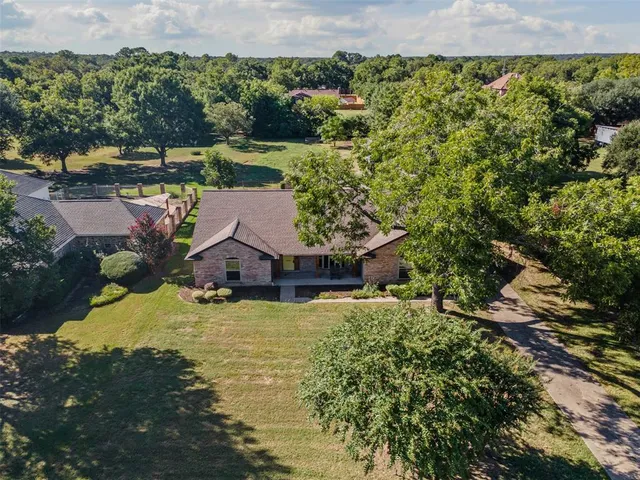 an aerial view of a house with a yard and lake view