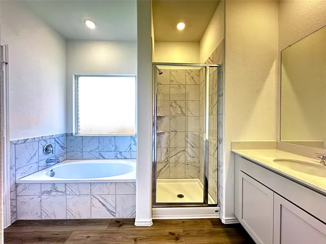 a bathroom with a granite countertop sink a mirror and a bathtub