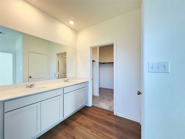a spacious bathroom with a double vanity sink and a mirror