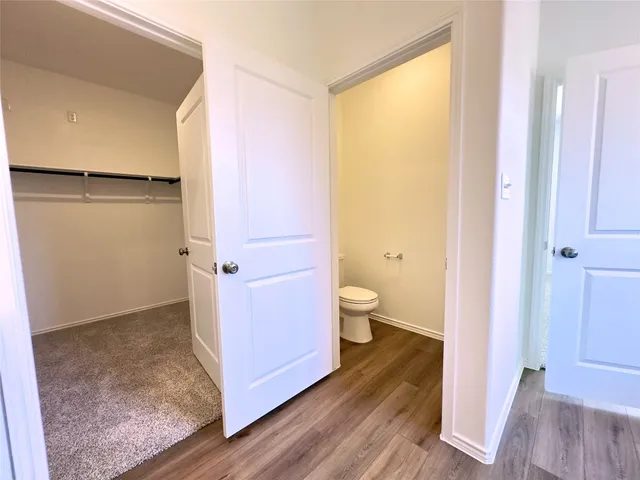 a very nice looking room with wooden floor and a bathroom