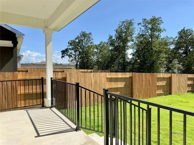 a view of a balcony with wooden floor and fence