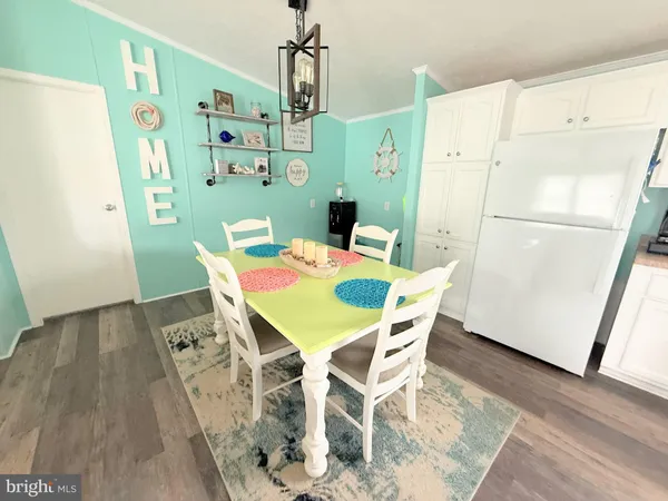 a view of a dining room with furniture wooden floor and a refrigerator