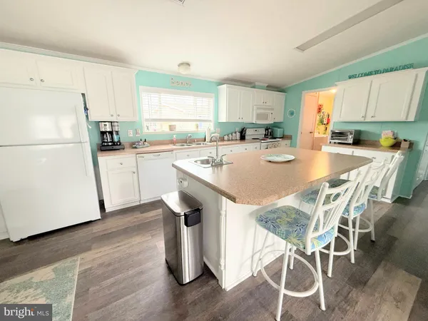 a kitchen with stainless steel appliances a table chairs refrigerator and wooden cabinets