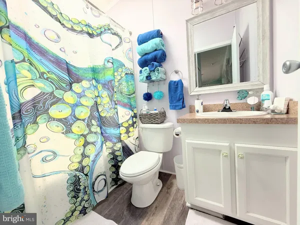 a white toilet sitting next to a wooden floor