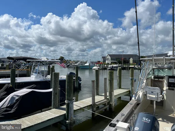 a view of swimming pool with seating area and trees in the background