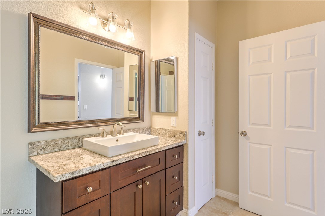 9050 West Warm Springs Road, Unit 2033 Las Vegas, NV 89148 - Photo 19 of 30 A vessel sink atop a sleek vanity offers both style and practicality in this well-appointed bath.