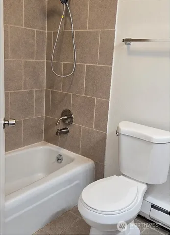 a white toilet sitting next to a bath tub