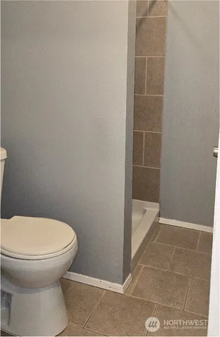 a bathroom with a toilet and a shower