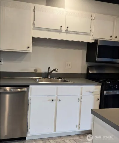 a kitchen with stainless steel appliances granite countertop a sink and a stove