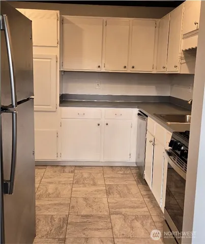a view of kitchen with refrigerator and cabinets