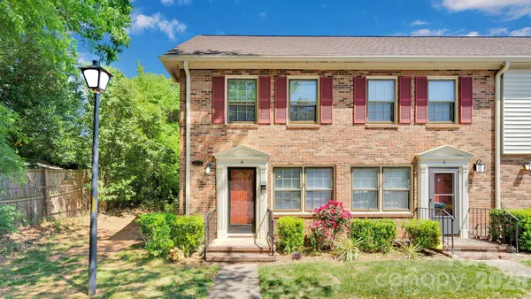 front view of a brick house with a yard