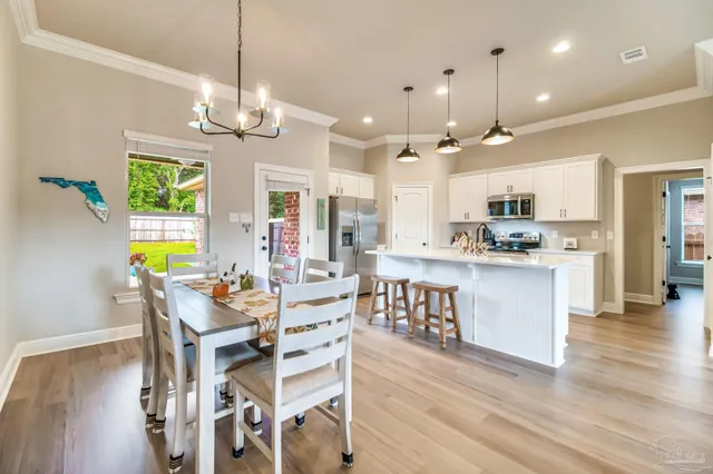 a view of a dining room with furniture a chandelier and wooden floor