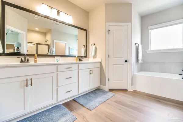a spacious bathroom with a sink double vanity and a mirror