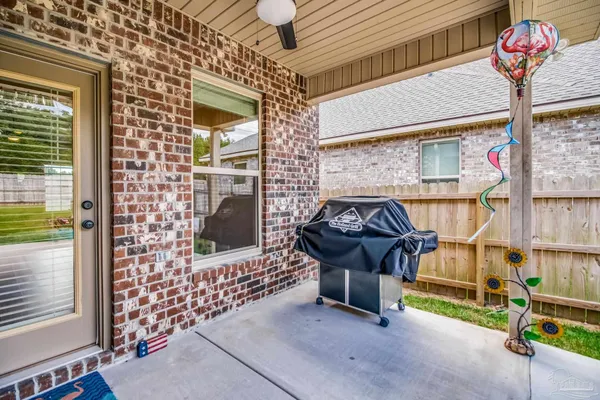 a view of backyard with a table and chair and potted plants