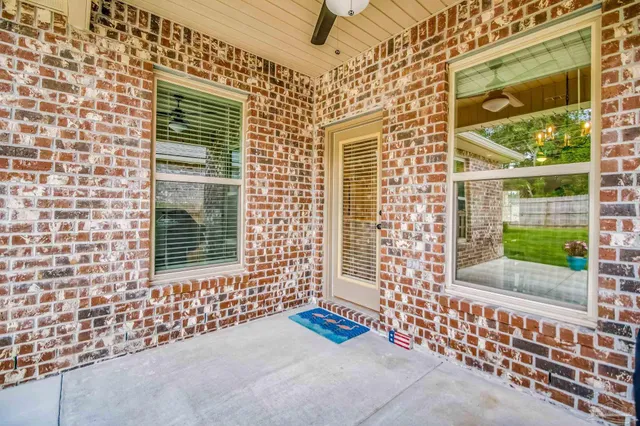 a view of backyard with a table and chair and potted plants