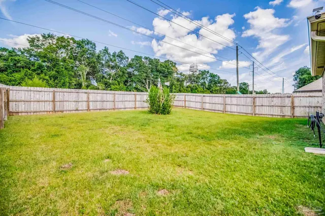 a view of an house with backyard space and balcony