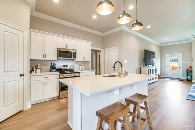 a kitchen with a sink white cabinets and stainless steel appliances