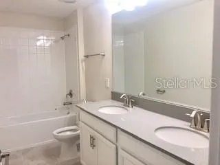 a bathroom with a granite countertop sink a toilet and shower
