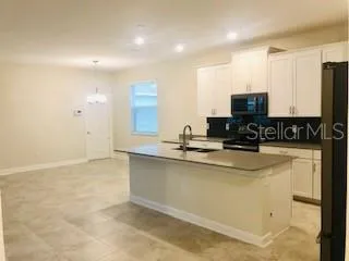 a kitchen with stainless steel appliances a sink a stove a microwave a sink a refrigerator and cabinets
