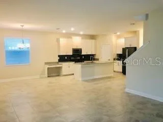 a view of a kitchen with kitchen island a sink a counter top space and appliances
