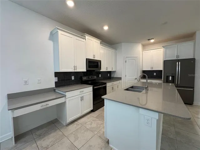 a kitchen with a refrigerator stove and microwave