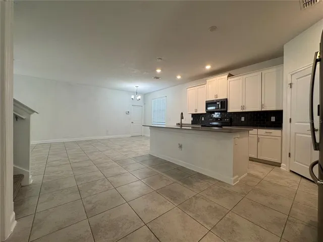 a kitchen with a sink a white cabinets and appliances