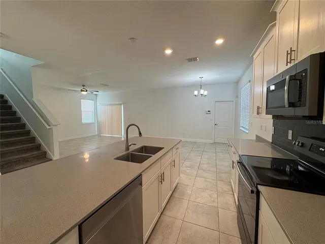 a kitchen with stainless steel appliances a sink a stove and microwave