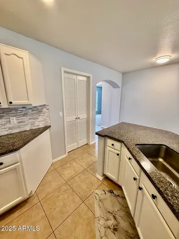 a kitchen with granite countertop a sink and a stove
