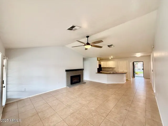 a view of a livingroom with a fireplace and a chandelier fan