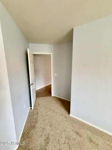 a view of a room with a ceiling fan and hardwood floor