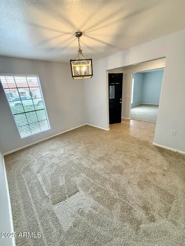 an empty room with windows and ceiling fan