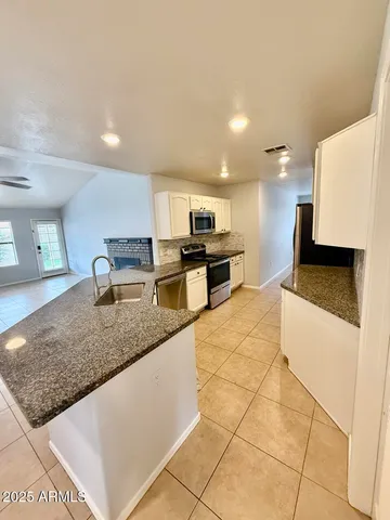 a kitchen with stainless steel appliances granite countertop a sink and a counter top