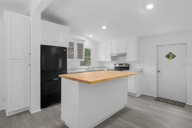 a kitchen with stainless steel appliances granite countertop a refrigerator and a sink
