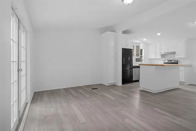 a view of a kitchen with a sink wooden floor and a window