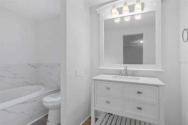 a bathroom with a granite countertop toilet a sink and a mirror