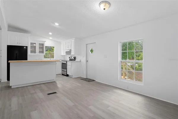 an empty room with windows and fireplace