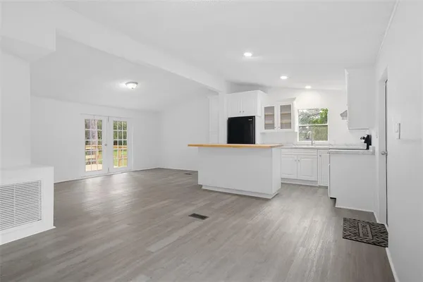 a view of empty room with wooden floor and window