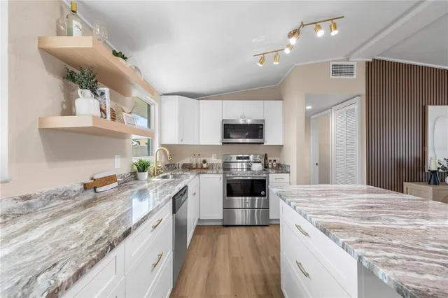 a kitchen with a stove sink and cabinets