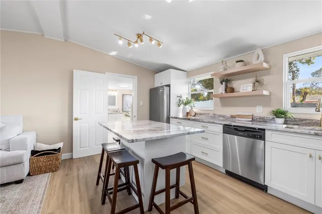 a kitchen with granite countertop white cabinets and stainless steel appliances