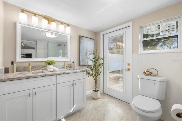 a bathroom with a toilet a sink and glass door
