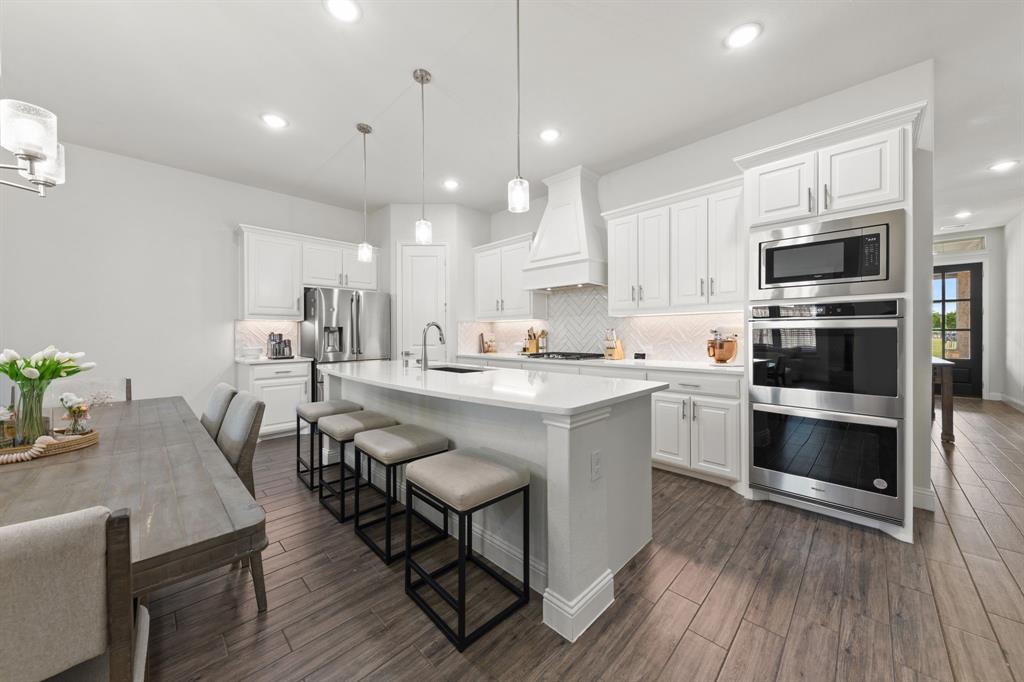 8808 Royal Star Road Rowlett, TX 75089 - Photo 2 of 40 a kitchen with stainless steel appliances kitchen island granite countertop a table chairs microwave and sink