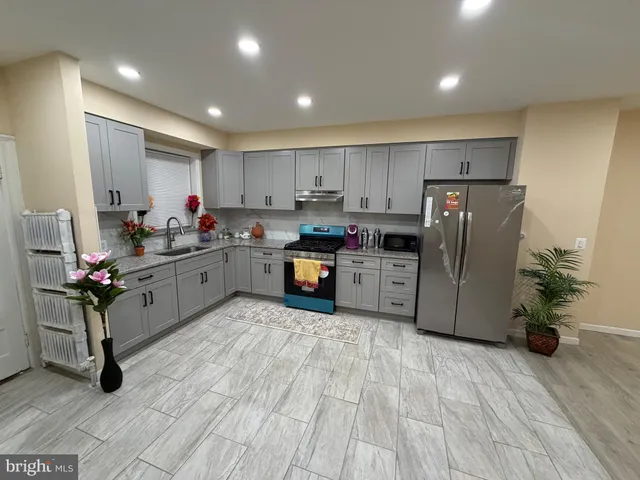 a kitchen with stainless steel appliances a refrigerator sink and cabinets