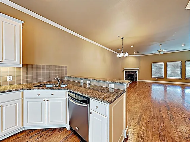 a kitchen with granite countertop a sink cabinets and wooden floor