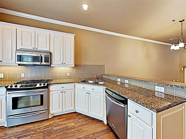 a kitchen with stainless steel appliances granite countertop a stove and a microwave