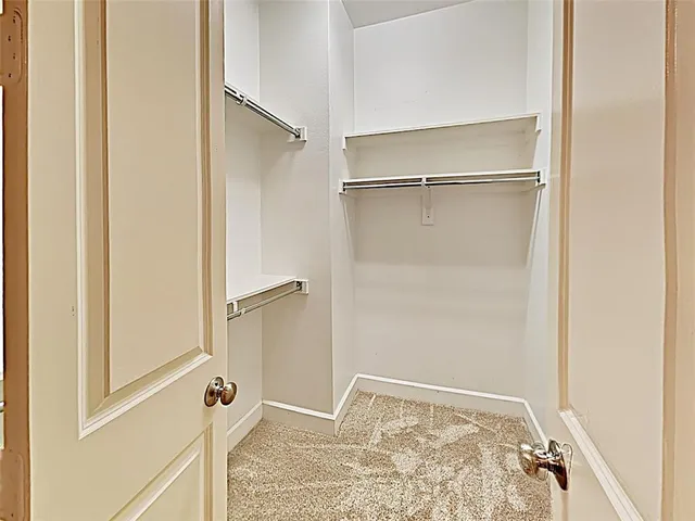 a view of walk in closet with empty racks