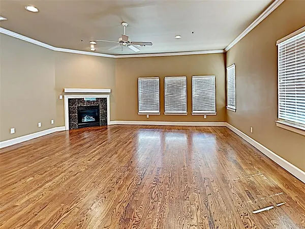 wooden floor fireplace and windows in an empty room