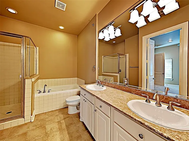 a spacious bathroom with a granite countertop sink mirror and a bathtub