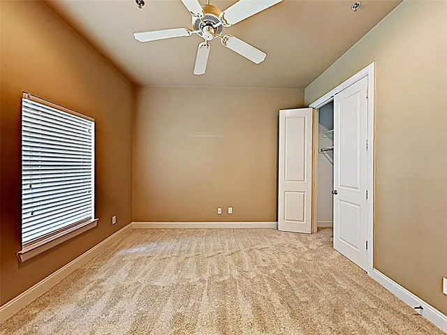 a view of an empty room with a chandelier fan